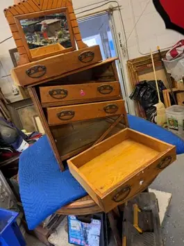 Before: a mirrored oak dresser in pieces, drawers out, on the workbench