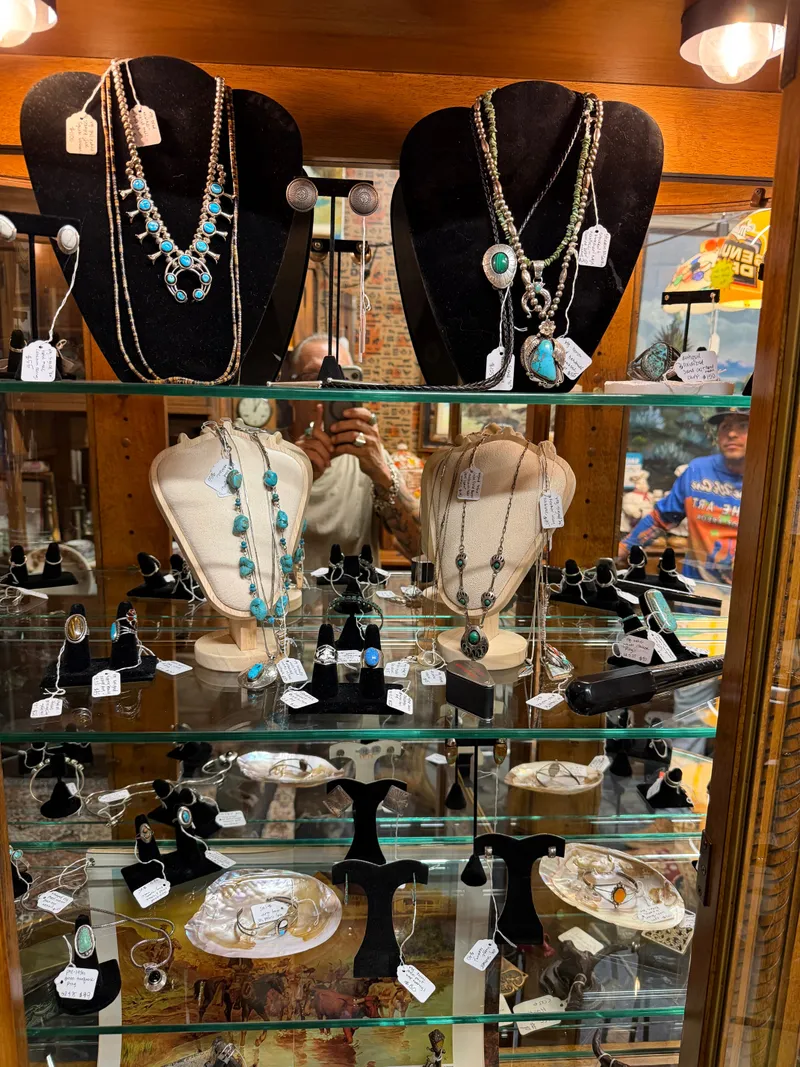 A lit glass case of turquoise and silver jewelry at Sample Studios: necklaces, rings, cuffs and earrings