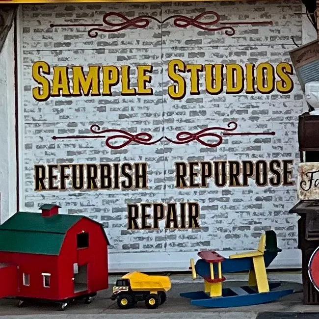 The Sample Studios sign on the storefront: Refurbish, Repurpose, Repair