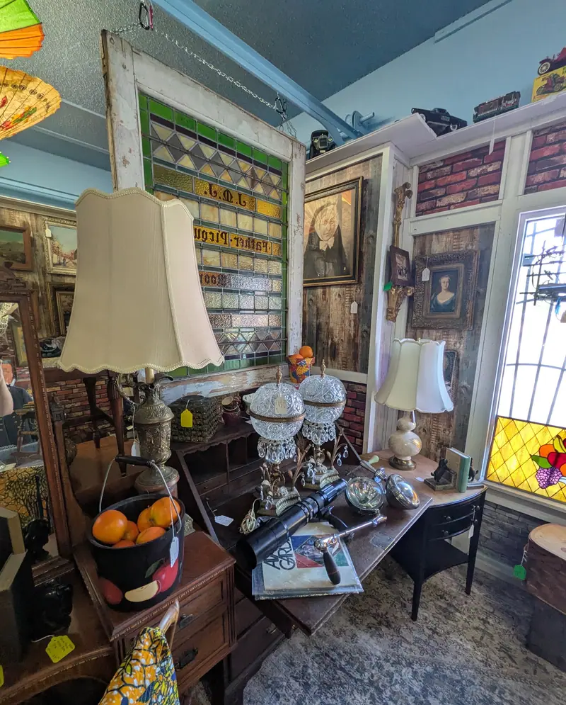 Lamps, a stained-glass window and a writing desk in a corner of Sample Studios