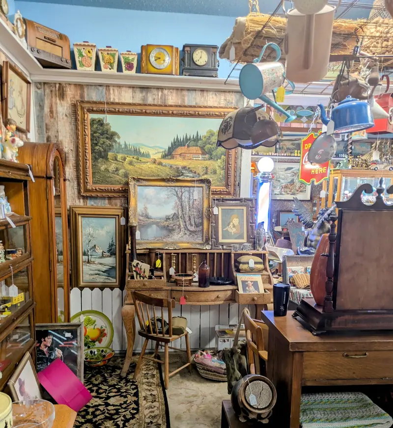 Framed landscape paintings above antique desks and cabinets at Sample Studios