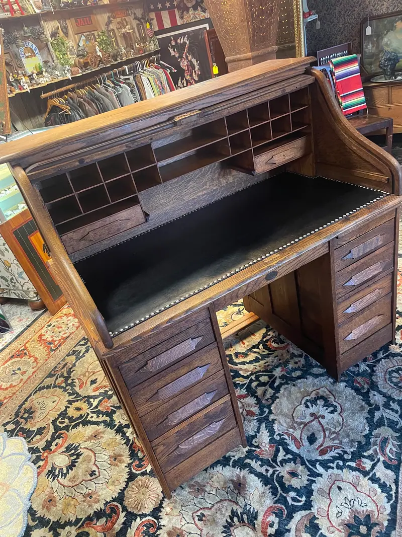 An oak roll-top desk on a patterned rug at Sample Studios