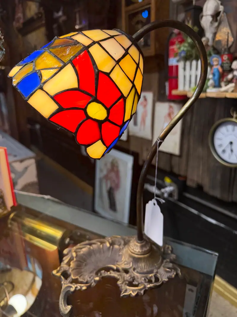 A stained-glass table lamp with a red flower shade at Sample Studios