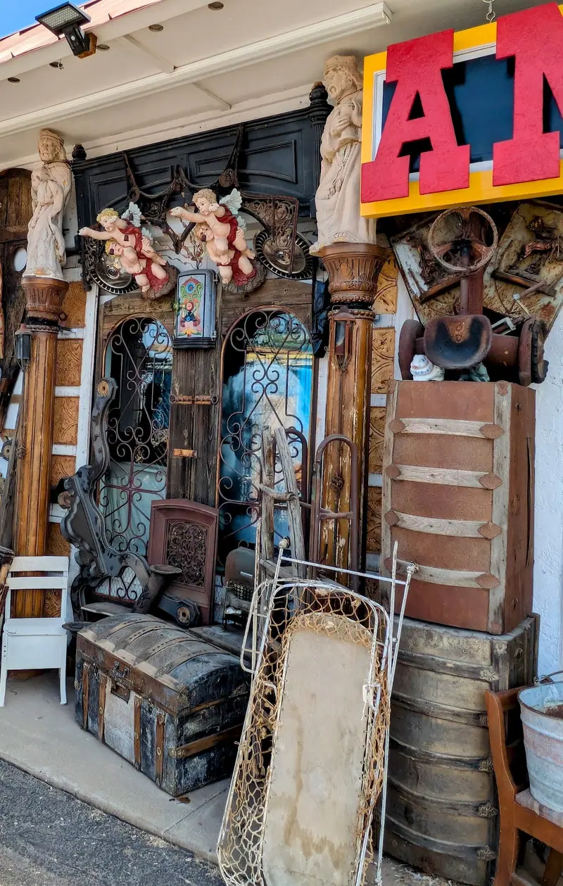 Old trunks, crates, chairs and carved columns outside Sample Studios on Apache Trail