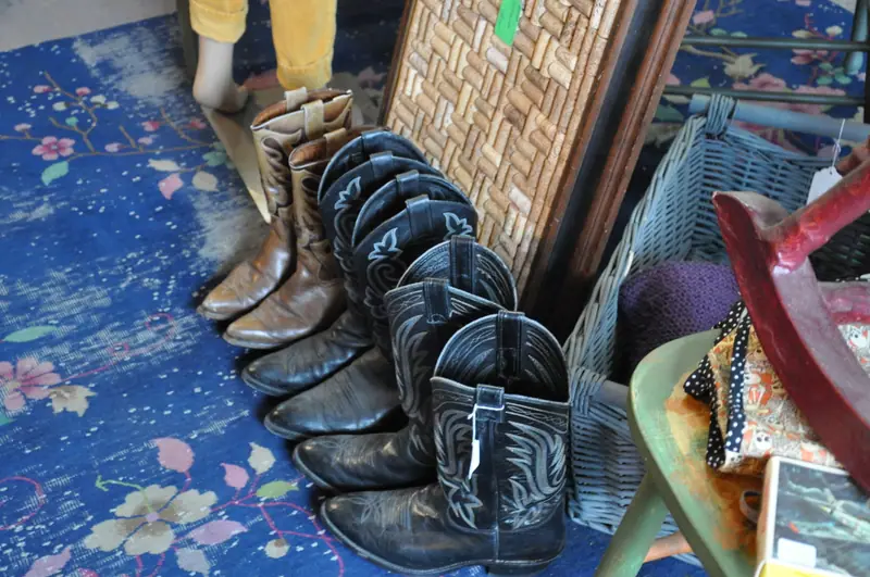 Pairs of vintage cowboy boots on a patterned rug at Sample Studios