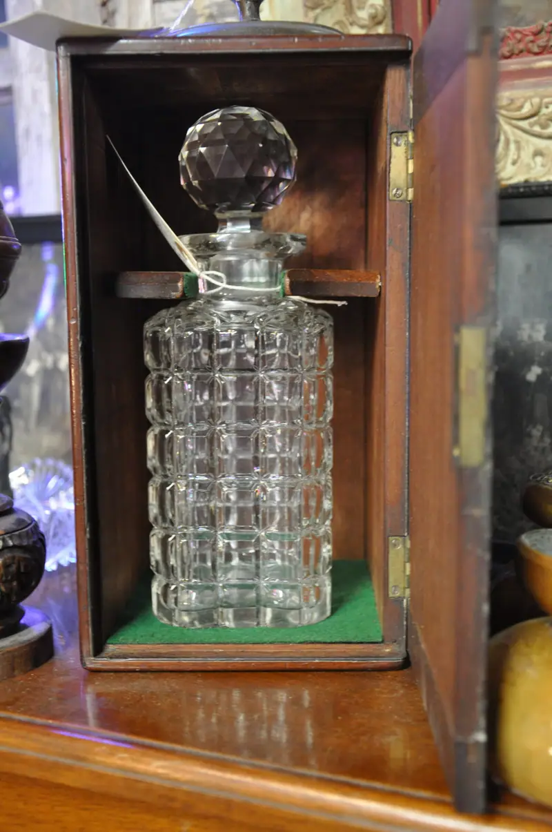 A cut-glass decanter in a wooden case