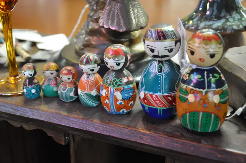 A row of hand-painted nesting dolls on a shelf at Sample Studios
