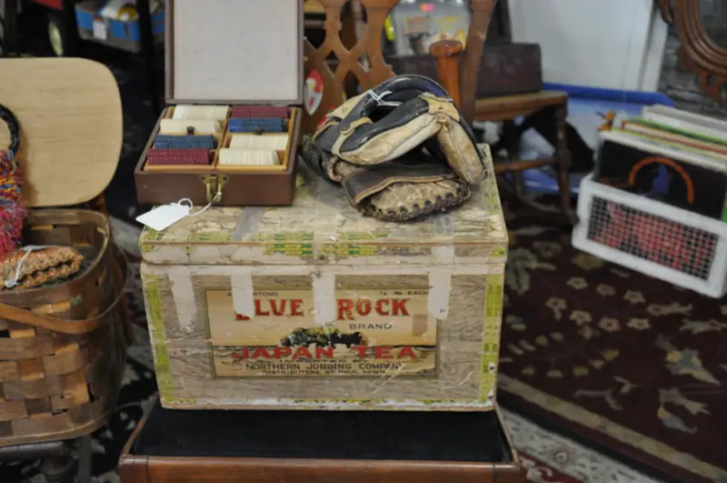 A vintage wooden crate, a baseball glove and old games on display at Sample Studios